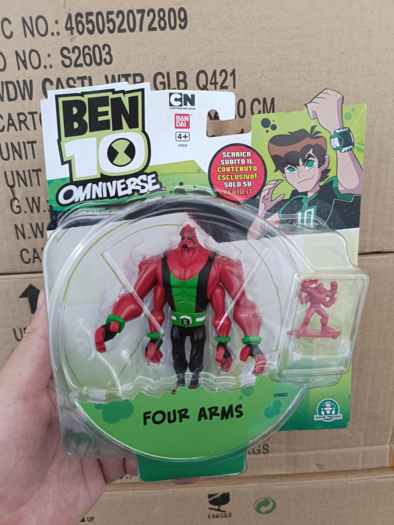 May include: A Ben 10 Omniverse action figure of Four Arms, a red and green character with four arms, in a clear plastic package. The package also includes a small red figure. The packaging features the Ben 10 logo and the text "FOUR ARMS".