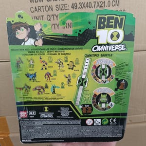 May include: A Ben 10 Omniverse toy package with a green and black color scheme. The package features cartoon illustrations of characters and the Omnitrix Shuffle game. The carton size is 19.4 x 16 x 8.3 inches.