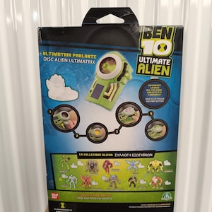 Pode incluir: Uma embalagem de brinquedo Ben 10 Ultimate Alien. A caixa &eacute; principalmente azul e verde, apresentando imagens do dispositivo Ultimatrix e v&aacute;rias figuras alien&iacute;genas. O texto inclui "Ultimatrix Parlante" e "Ultimate Alien".