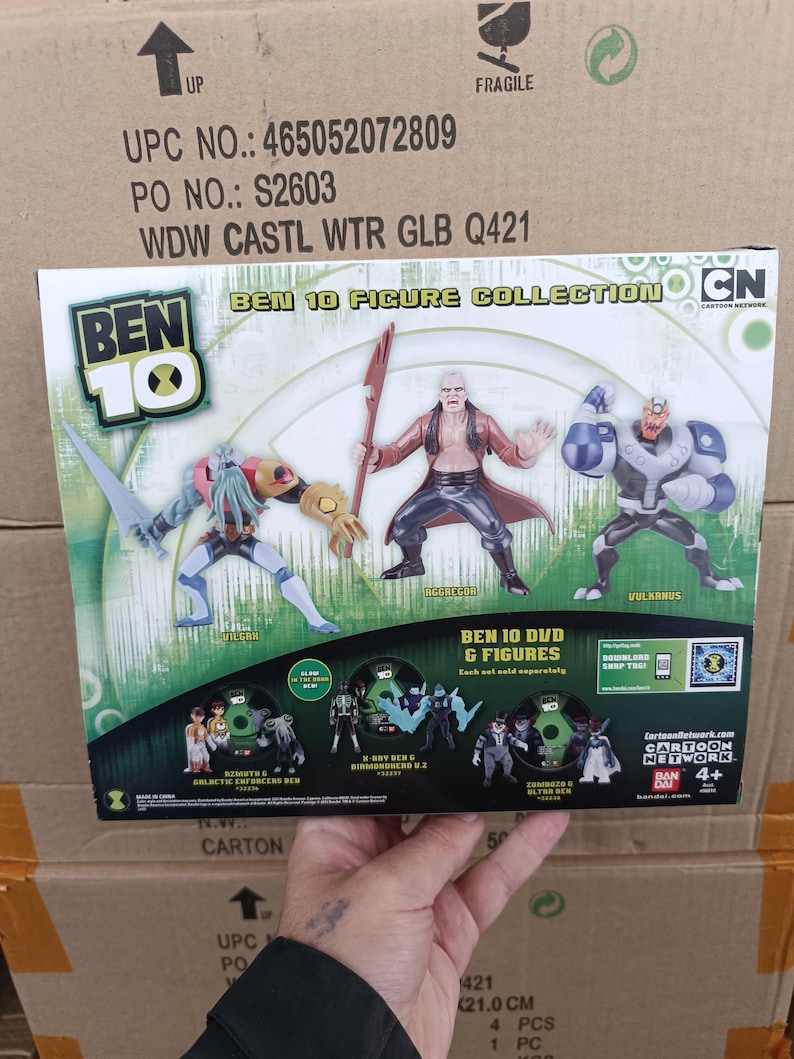 May include: A Ben 10 Figure Collection box featuring three action figures: Vilgax, Aggregor, and Vulkanus. The box also displays Ben 10 DVD & Figures. The Cartoon Network logo is visible. The box is on a cardboard surface.