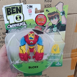 May include: A Ben 10 Omniverse Bloxx action figure in a clear plastic package. The figure is red, yellow, blue, and black. The packaging includes the Ben 10 Omniverse logo, CN logo, and the text "BLOXX".