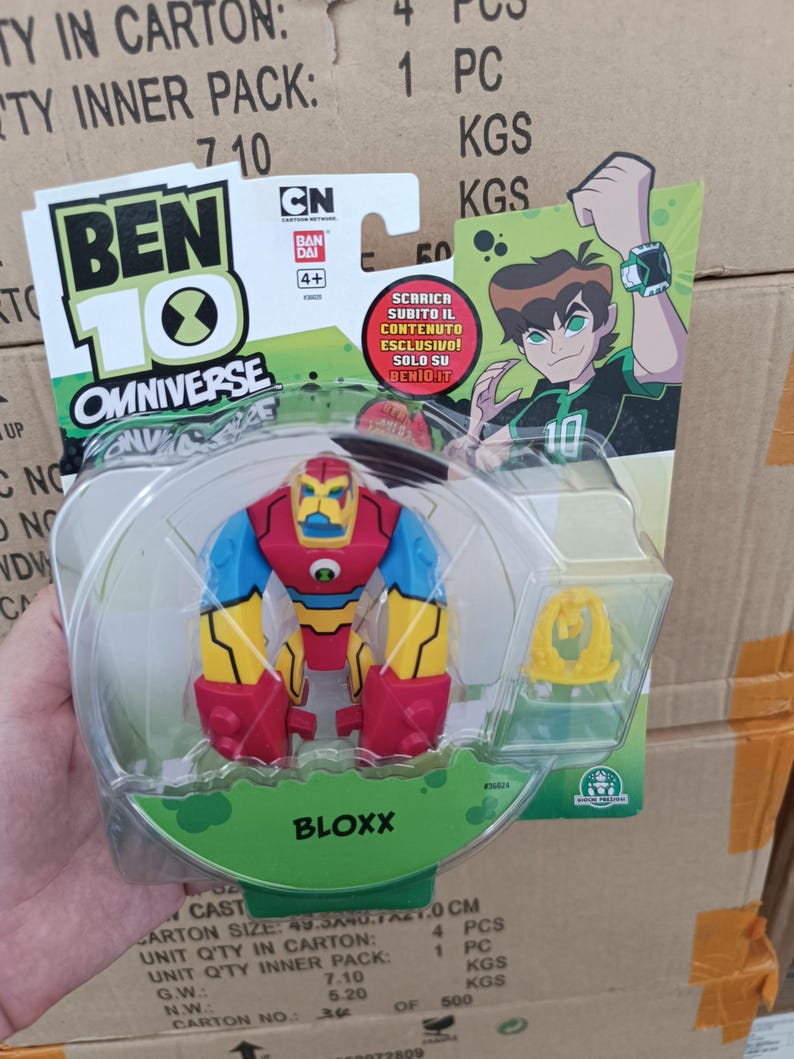 May include: A Ben 10 Omniverse Bloxx action figure in a clear plastic package. The figure is red, yellow, blue, and black. The packaging includes the Ben 10 Omniverse logo, CN logo, and the text "BLOXX".