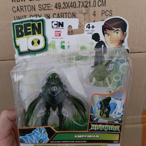 Puede incluir: Figura de acci&oacute;n de Ben 10 Ampfibian en un paquete de pl&aacute;stico transparente. La figura es principalmente verde oscuro y negra. El embalaje presenta el logotipo de Ben 10, el logotipo de Cartoon Network y el nombre del personaje. Tama&ntilde;o de la caja: 49,3x40,7x21,0 cm.