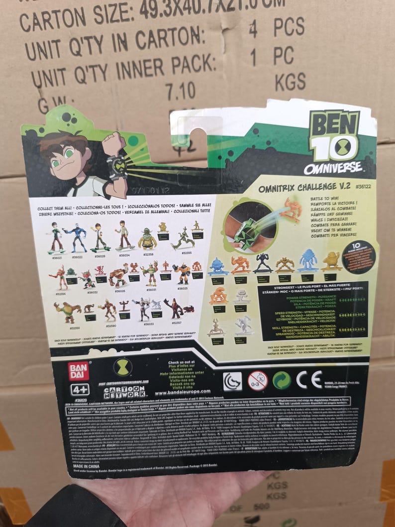 Puede incluir: Embalaje de figura de acci&oacute;n Ben 10 Omnitrix Challenge V.2. La parte posterior del paquete presenta im&aacute;genes de varias figuras de acci&oacute;n, el logotipo de Ben 10 y el logotipo de Cartoon Network. El paquete es verde, negro y blanco.