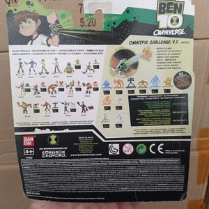 May include: Ben 10 Omnitrix Challenge V.2 action figure packaging. The back of the package features illustrations of various characters and the Omnitrix device. The package includes the Cartoon Network logo and the Bandai logo.