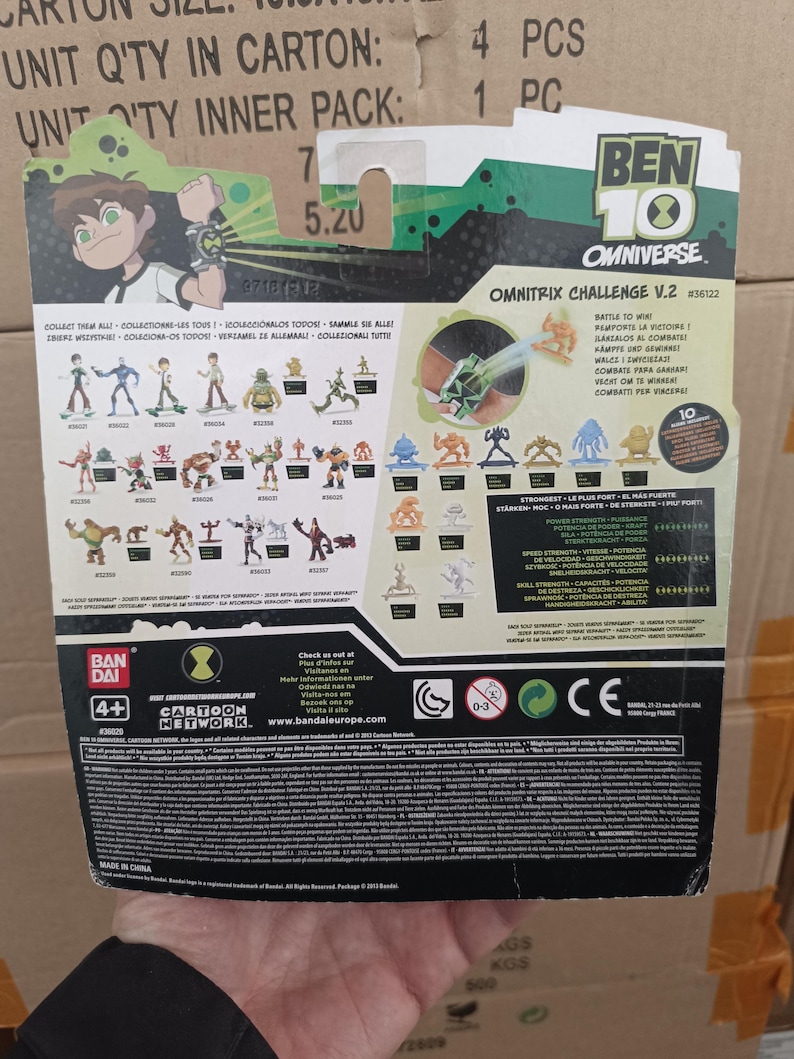 May include: Ben 10 Omnitrix Challenge V.2 action figure packaging. The back of the package features illustrations of various characters and the Omnitrix device. The package includes the Cartoon Network logo and the Bandai logo.