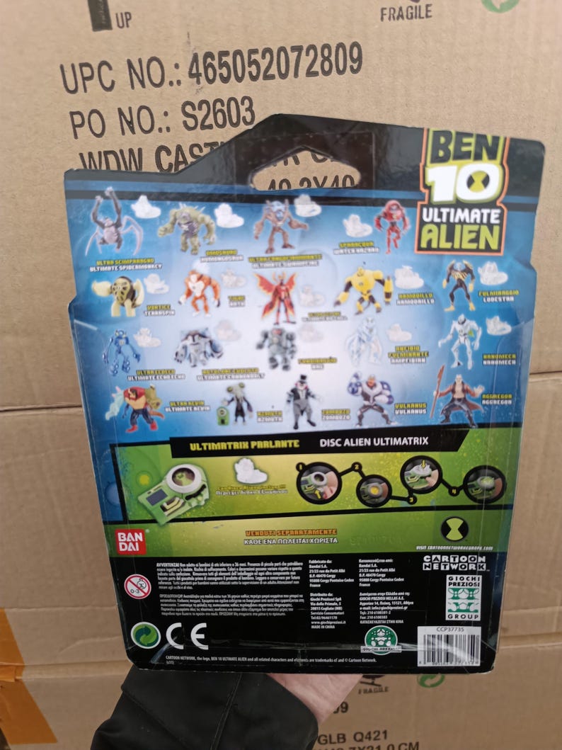 May include: The back of a Ben 10 Ultimate Alien toy package. It features various alien figures, the text "ULTIMATRIX PARLANTE" and "DISC ALIEN ULTIMATRIX", and the Cartoon Network logo. The package is blue, green, and black.