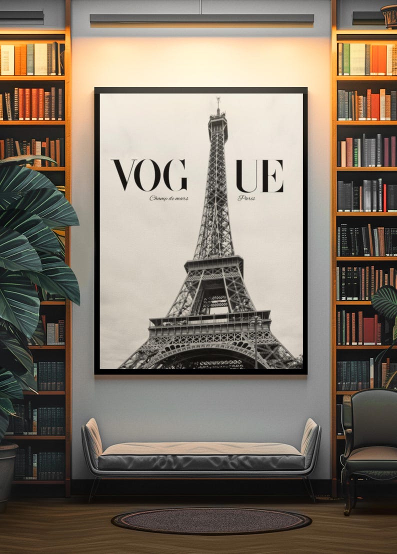 May include: Monochrome framed print of the Eiffel Tower with the text "VOGUE Champ de mars Paris". The print hangs above a bench in a room with bookshelves and a large potted plant.