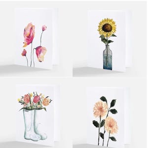May include: Set of four floral watercolor art cards. The cards feature various flower arrangements, including pink poppies, a sunflower in a vase, tulips in rain boots, and peach-colored dahlias. The text "Set 1 - Flowers" is at the top.