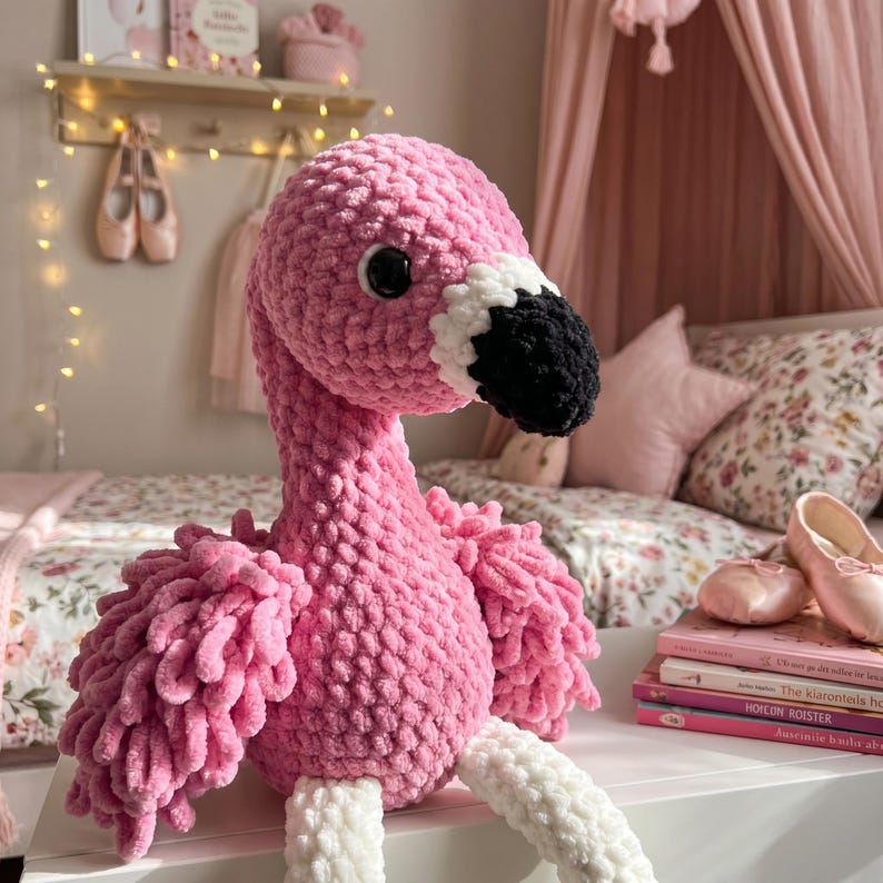 Close up of handmade crochet flamingo plush toy showing detailed chenille texture and craftsmanship
