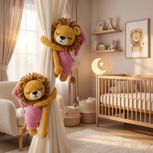 May include: Two handmade crochet lion curtain tiebacks featuring yellow yarn bodies, brown manes, and pink sleeping caps. Each lion has closed eyes, a black stitched nose, and long arms wrapped around a cream-coloured fabric curtain panel.