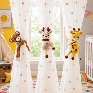 May include: Three white sheer curtains with small colourful polka dots, each held back by a crocheted animal tieback. The tiebacks feature a brown monkey, a beige deer with antlers, and a yellow giraffe with brown spots, all with arms wrapped around.