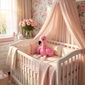Crochet flamingo nursery decoration beside baby crib, handmade pink bird plush for girls