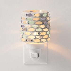 May include: A white night light with a cylindrical shade decorated with small, colorful fish. The fish are in shades of blue, green, and yellow. The night light plugs directly into a wall outlet and has an on/off switch.