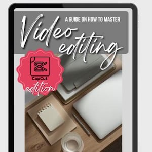 May include: A digital tablet displays a guide on video editing, "CapCut edition." The image includes a laptop, notepad, pen, and a glass of water on a wooden surface. The tablet has a black border.