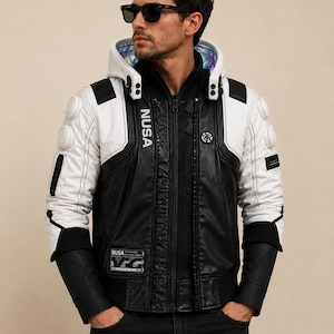 May include: A black and white jacket featuring a hood with an iridescent interior lining. The jacket has white sleeves with circular accents, black leather-like panels, and the text NUSA printed vertically on the chest and on a rectangular patch.