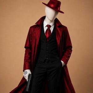 Puede incluir: Maniquí vestido con un abrigo largo burdeos, sombrero fedora a juego y corbata. El atuendo incluye un chaleco negro, camisa y pantalones. Un guante blanco con un tatuaje sostiene una pistola negra. El fondo es de color beige.