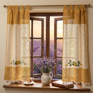 Può includere: Due tende all'uncinetto con bordo superiore e inferiore giallo senape e pannello centrale color crema. Ogni tenda presenta un motivo floreale ricamato con fiori gialli e foglie verdi. Le tende sono appese a un bastone in ottone.