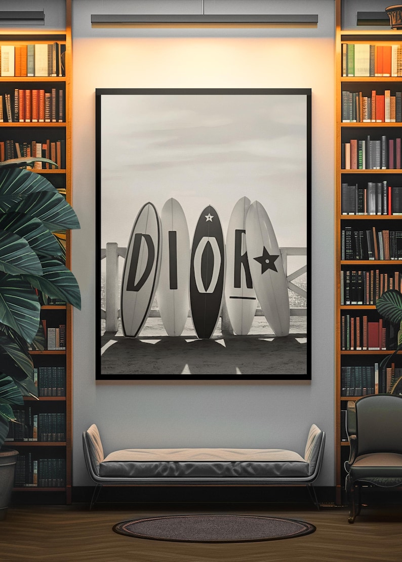 May include: Black and white framed print featuring five surfboards leaning against a wooden fence. The surfboards display the word "DIOR" in bold letters and a star. The image is in a sepia tone, evoking a vintage aesthetic.