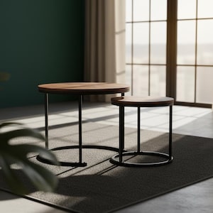 May include: Two modern, round coffee tables with dark wood tops and black metal legs. The larger table is approximately 24 inches in diameter, and the smaller table is about 16 inches in diameter. They sit on a dark gray rug.
