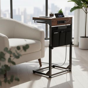 May include: A modern side table with a dark brown wood top and black metal frame. It features a built-in power strip, storage pockets, and a charging station. The table is next to a cream-colored armchair.