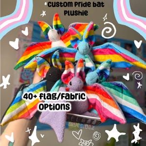 May include: A selection of plush bat toys with rainbow wings and different body colours. The image includes text that reads "*Custom Pride bat PLUSHIE" and "40+ flag/fabric OPTIONS". The bats are shown against a background with decorative elements.