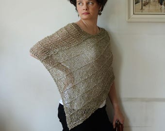 Op de afbeelding: Een goudkleurige poncho met open weefsel en een V-hals. De poncho is gemaakt van een lichtgewicht, mogelijk gebreid materiaal. Het kledingstuk heeft een losse, vloeiende pasvorm en drapeert over de schouders.