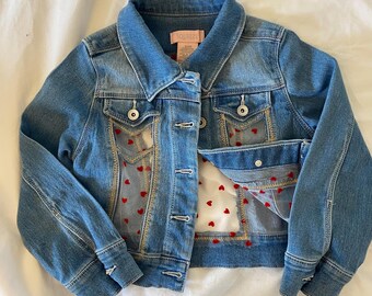 Tela vaquera infantil, reciclada, con inserciones de corazones de malla cosidas a máquina.