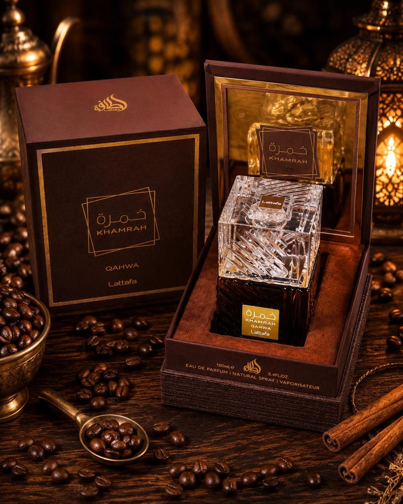May include: A Lattafa Khamrah Qahwa eau de parfum bottle with a clear, faceted glass cap and a dark brown base, presented in an open brown box. The label reads Khamrah Qahwa Lattafa, with 100ml and 3.4 fl oz printed on the box edge.