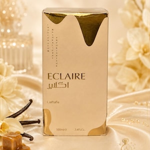 May include: A rectangular perfume box in beige and gold with a metallic drip design at the top. The text reads Eclaire, Lattafa, 100ml, 3.4FL.OZ, and includes Arabic script. The box features vertical text stating Eau de Parfum and Vaporisateur Natural Spray.