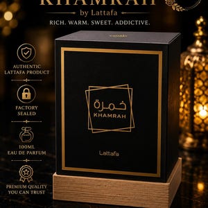 May include: A black rectangular perfume box with gold trim and the text Khamrah by Lattafa. The box features the Arabic script for Khamrah, the phrase Rich. Warm. Sweet. Addictive., and icons indicating a 100ml Eau de Parfum, authentic product, and factory seal.
