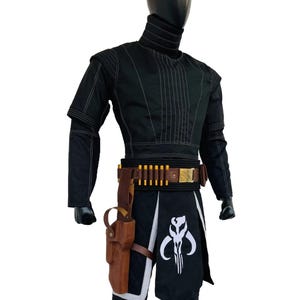 May include: Black costume with white stitching, high collar, and a belt with gold details. Includes a holster and a black skirt with a white emblem. The outfit is displayed on a mannequin.