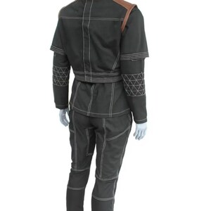 May include: A dark green two-piece outfit with white stitching and brown shoulder accents. The jacket has a high collar and short sleeves. The pants have a fitted design. The outfit is displayed on a mannequin.