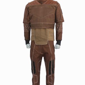 May include: A brown long-sleeved shirt and matching pants set featuring a high collar, white topstitching, and geometric patterns on the sleeves. The shirt has a layered chest panel, while the pants include black rectangular accents on the legs.
