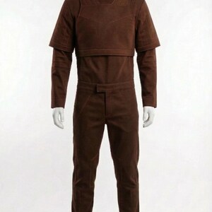 May include: A brown jumpsuit with a high collar and short sleeves, displayed on a mannequin. The outfit includes matching pants and boots. The overall style suggests a futuristic or space-age theme.