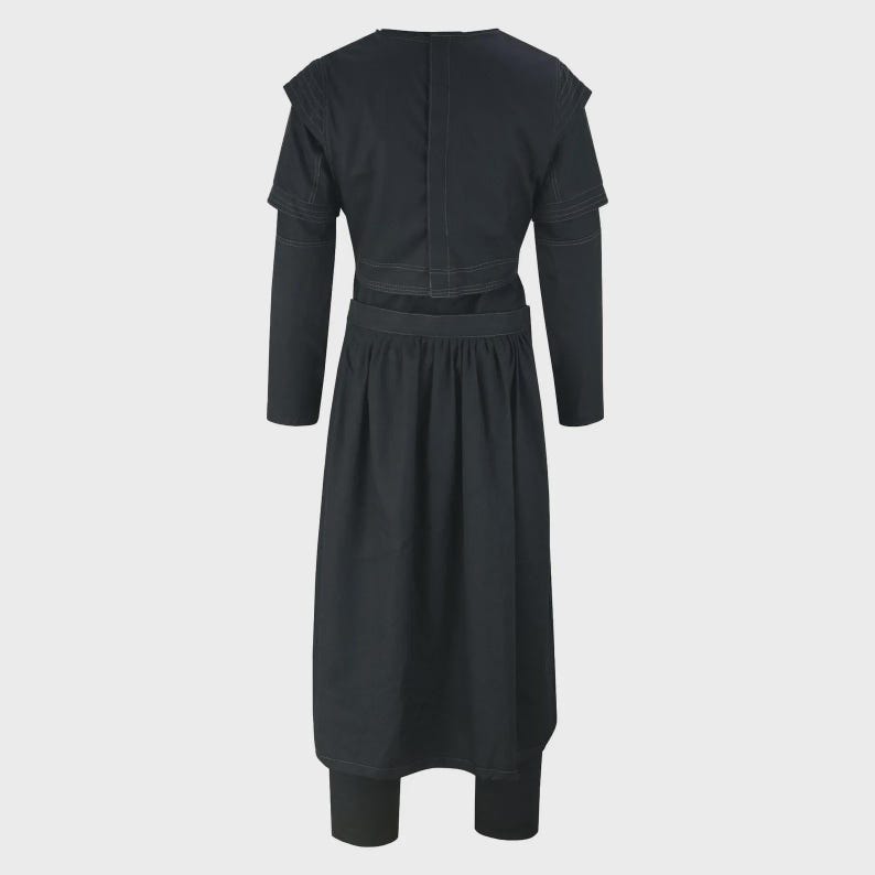 May include: A black, two-piece outfit featuring a long-sleeved top with shoulder detailing and a skirt-like bottom. The outfit appears to be made of a dark fabric, possibly denim or a similar material. The back view of the outfit is shown.