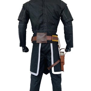 May include: Black costume with white edging, a brown belt, and a holster. The costume features a jacket with short sleeves and a high collar. The belt has a brown leather pouch and several gold cylinders. The trousers have white trim.