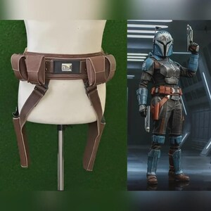 May include: Brown leather utility belt with pouches and straps, displayed on a mannequin. The belt has a rectangular buckle. A person in a costume is shown on the right, wearing a similar belt.