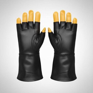 May include: A pair of black gloves with extended cuffs and yellow fingertips. The gloves feature a smooth, leather-like texture on the palms and back, with distinct yellow caps covering each finger and thumb, providing a contrast to the black body.