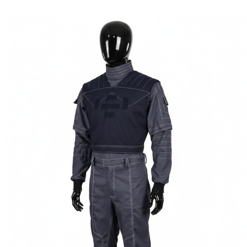 May include: A dark blue and gray uniform displayed on a mannequin. The uniform includes a high-collared shirt, a vest with a geometric design, and matching pants. White stitching accents the seams. Black gloves complete the outfit.