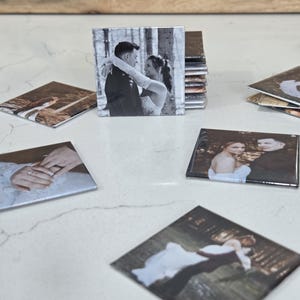 Pode incluir: Uma cole&ccedil;&atilde;o de porta-copos quadrados com fotografias a preto e branco e a cores de um casal com trajes de casamento. As imagens retratam v&aacute;rias cenas, incluindo um casal a abra&ccedil;ar-se, um grande plano de m&atilde;os com an&eacute;is e a dan&ccedil;ar.