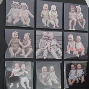 Pode incluir: Um painel de exibi&ccedil;&atilde;o preto com nove impress&otilde;es fotogr&aacute;ficas quadradas dispostas em grade. Cada impress&atilde;o mostra um par de beb&ecirc;s com v&aacute;rias roupas, incluindo jaquetas com capuz, jardineiras, vestidos e camisas, em diferentes poses.