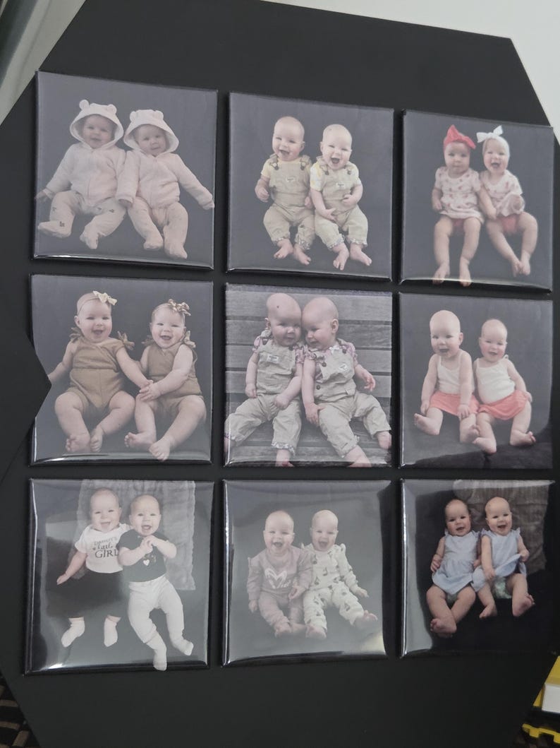 Pode incluir: Um painel de exibi&ccedil;&atilde;o preto com nove impress&otilde;es fotogr&aacute;ficas quadradas dispostas em grade. Cada impress&atilde;o mostra um par de beb&ecirc;s com v&aacute;rias roupas, incluindo jaquetas com capuz, jardineiras, vestidos e camisas, em diferentes poses.
