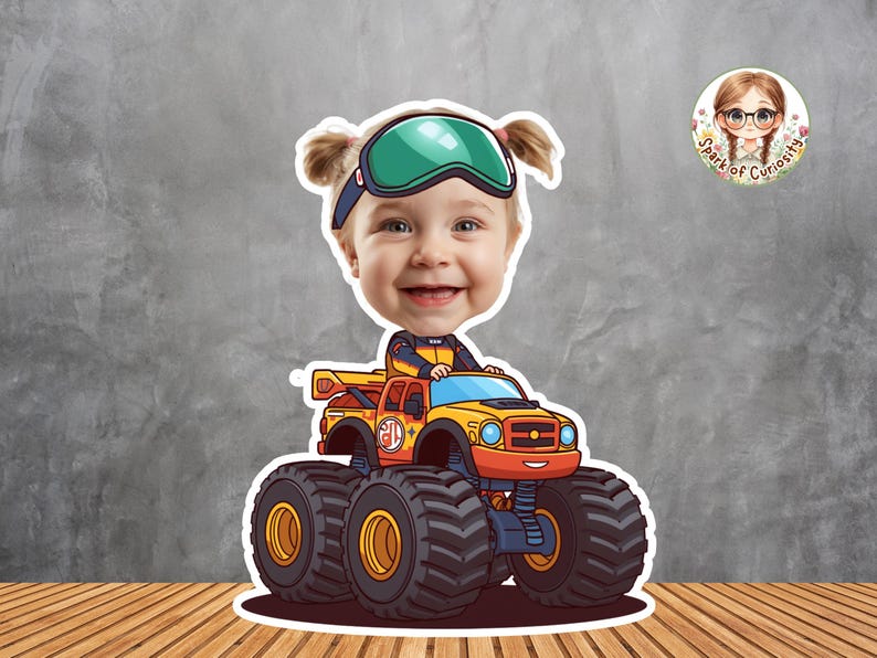 Peut inclure: Autocollant repr&eacute;sentant un visage d'enfant sur un monster truck de dessin anim&eacute;. Le camion est orange et jaune avec de gros pneus noirs. L'enfant porte des lunettes. Un petit logo circulaire est dans le coin sup&eacute;rieur droit.