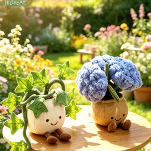 K&ouml;nnte beinhalten: Zwei Pl&uuml;schpflanzenspielzeuge auf einem Holztisch in einem Garten. Eines ist ein wei&szlig;er Topf mit gr&uuml;nen Bl&auml;ttern, das andere ein beigefarbener Topf mit blauen Blumen. Beide haben l&auml;chelnde Gesichter und braune Beine.