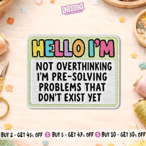 May include: A rectangular embroidered patch with a light green border. The top section features the text HELLO I'M in colorful letters. The white lower section contains the black embroidered text NOT OVERTHINKING I'M PRE-SOLVING PROBLEMS THAT DON'T EXIST YET.