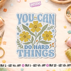 May include: A rectangular embroidered patch featuring the text YOU CAN DO HARD THINGS in light blue thread. The design includes three yellow flowers with green stems and leaves, accented by small blue and orange floral details.