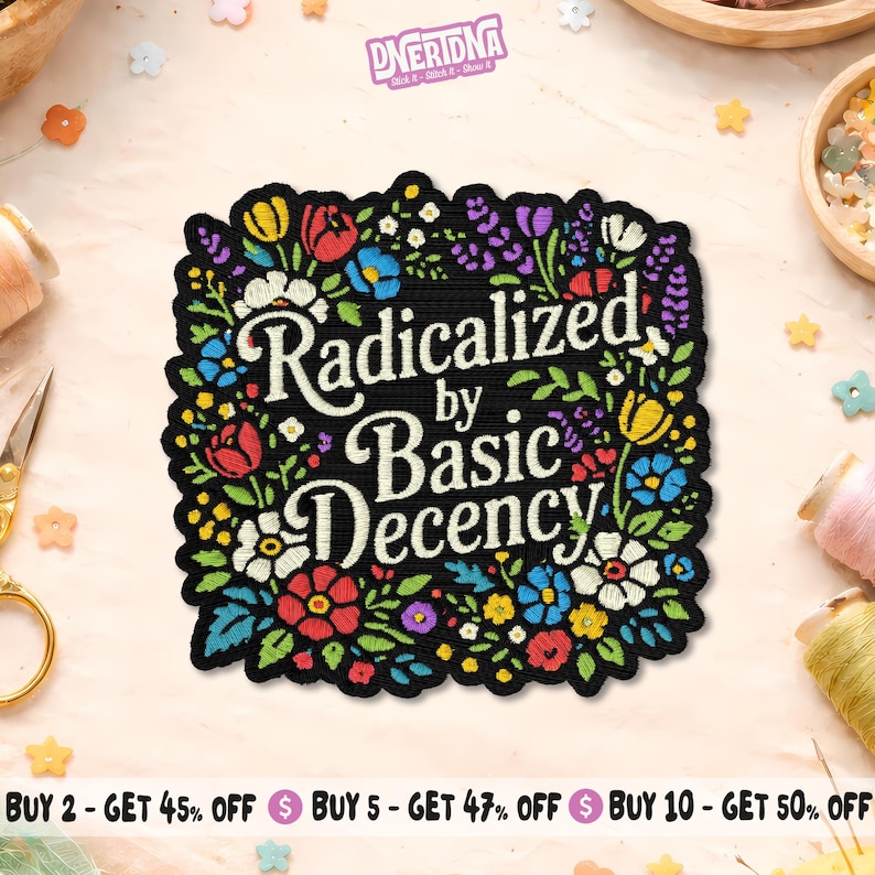 Pode incluir: Patch preto com o texto "Radicalized by Basic Decency" em branco, rodeado por uma borda floral colorida. As flores s&atilde;o vermelhas, amarelas, azuis e roxas. Provavelmente um patch para passar a ferro ou costurar.