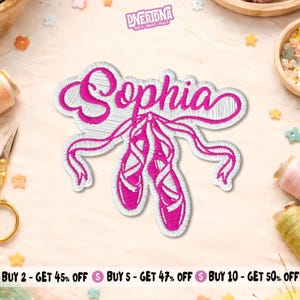 May include: An embroidered iron-on patch featuring the name Sophia in bright pink cursive script, positioned above a pair of pink ballet slippers with long, flowing ribbons. The design is outlined in white thread, creating a clean, decorative look.