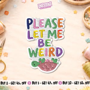 Peut inclure: Un autocollant découpé présentant le texte PLEASE LET ME BE WEIRD dans un style brodé avec des fils multicolores sur fond blanc. Sous le texte se trouve une petite illustration cousue d'une créature ronde rose avec des feuilles vertes.
